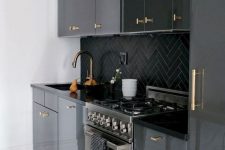 a modenr black kitchen refreshed with white surfaces and with gold handles all over that add a touch of glam