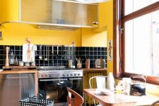 a retro kitchen done in bright yellow and black, with chic mid-century modern furniture and touches of warm stained wood