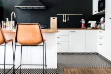 a welcoming white kitchen with butcherblock countertops and a chalkboard wall instead of a backsplash plus leather stools