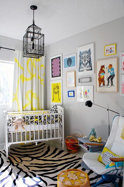 a whimsy nursery with a printed rug, colorful print curtains, a brigth gallery wall and lots of colorful elements