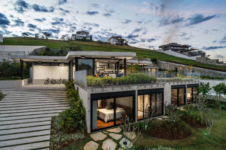 This contemporary house is built into a steep slope and it takes all the advantages from it in the best way possible