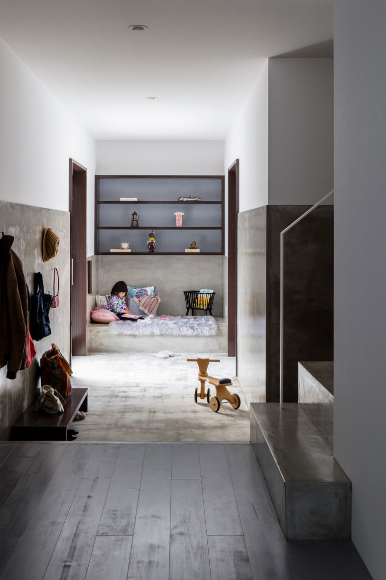 This is a small kid's nook done with built-in shelves, a concrete platform bed and two doors to outside