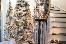 02 a chic winter fairy tale entryway with tree flocked Christmas trees, lights and neutral ornaments plus candles around