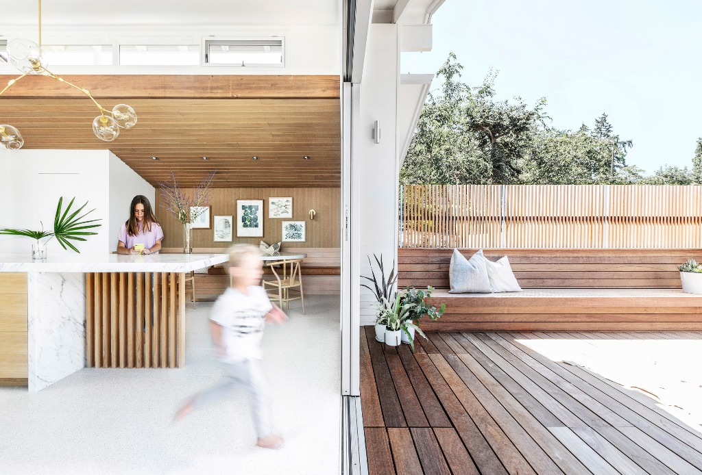 Glazed sliding doors allow entrance to the deck, which is clad with natural wood and indoors and outdoors are interconnected