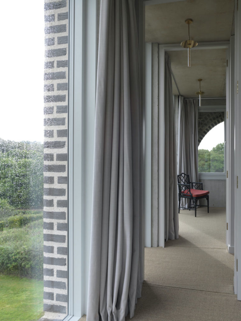 Soft curtains and rugs soften the look of the raw concrete everywhere
