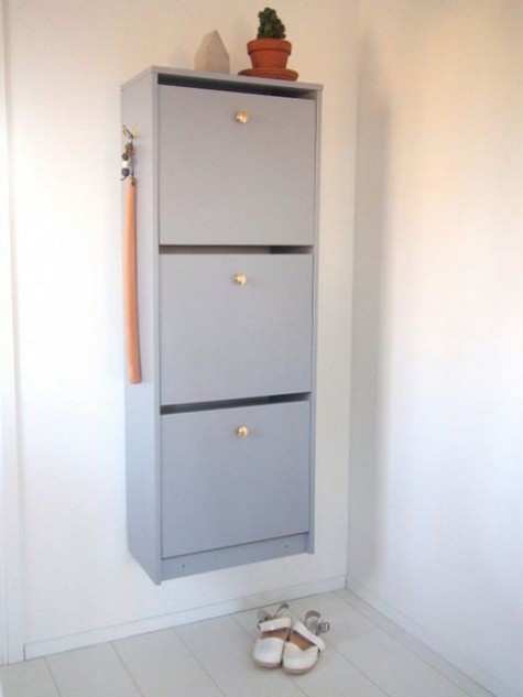 A light grey IKEA Bissa cabinet with elegant gilded knobs is a stylish contemporary idea for storing your shoes