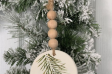 04 a rustic Christmas ornament of a wood slice with painted evergreens, wooden beads and twine is very fun and cool