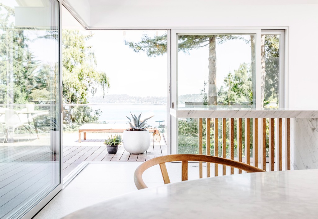 Glazed walls and doors allow amazing views and the terrace is decorated in a minimal way, with just a couple of furniture pieces