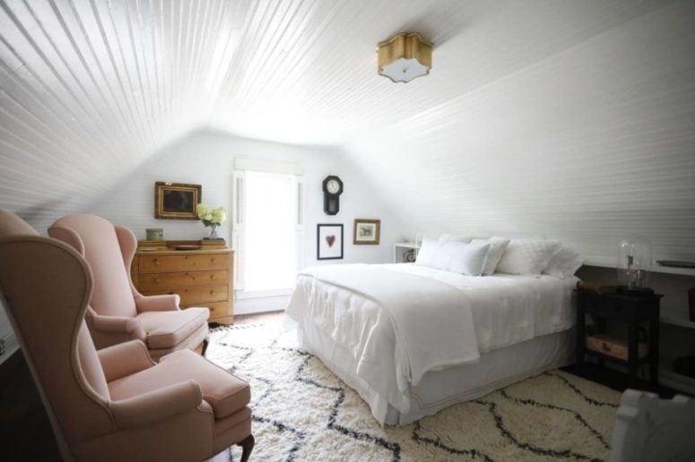 The bedroom is decorated with shiplap, there's vintage furniture and amazing wingback chairs that add charm