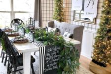 05 a cozy farmhouse dining space with tall Christmas trees with lights is a chic idea to rock for holidays