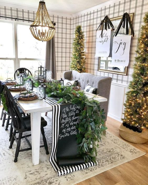 a cozy farmhouse dining space with tall Christmas trees with lights is a chic idea to rock for holidays
