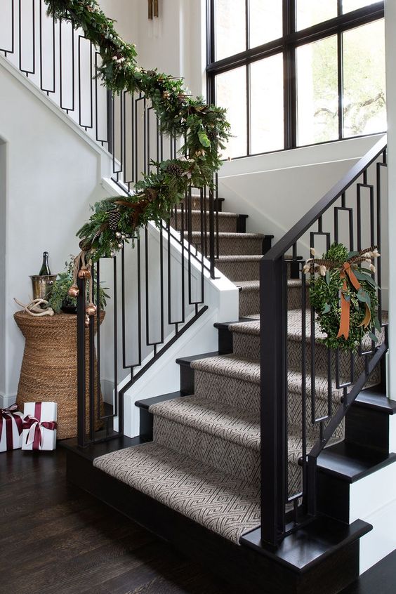 a greenery garland with pinecones covering the railing will bring a festive spirit to the space