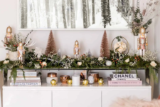 06 a greenery garland with white blooms and berries on the console table to brign a festive spirit to your living room or entryway