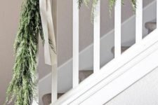 07 a greenery garland with white bows to style your railing in farmhouse style with a touch of vintage