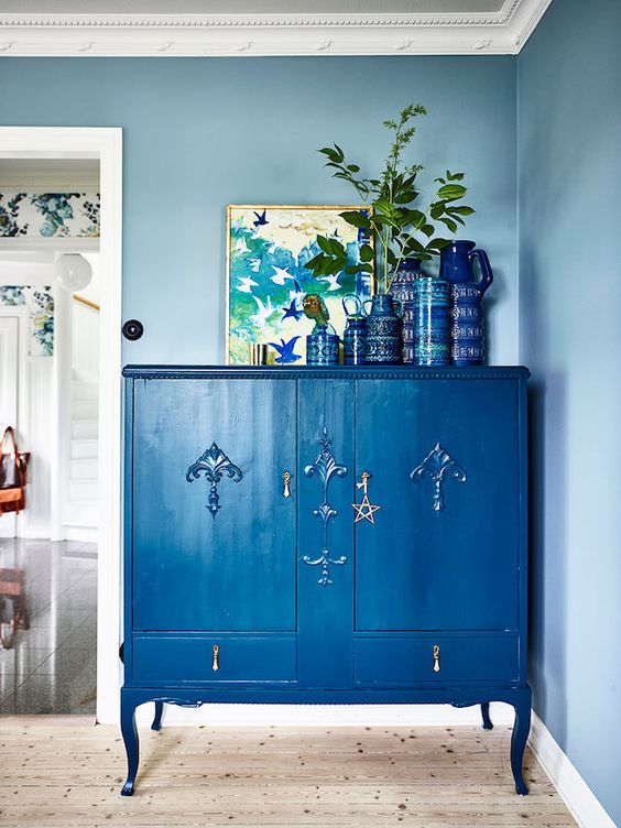 a refined vintage dresser painted classic blue and accented with a star plus blue pottery on top for an edgy touch