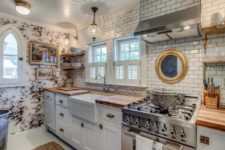 08 The kitchen features subway tiles, floral wallpaper, farmhouse style cabinets and a crystal pendant lamp