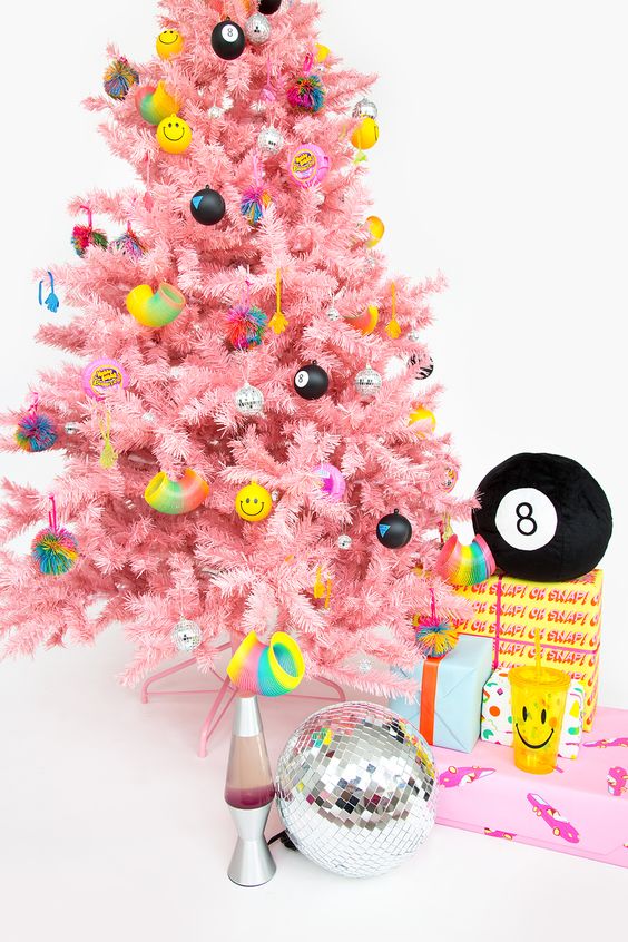 a bright pink Christmas tree with funny and colorful modern ornaments looks fresh and very bold
