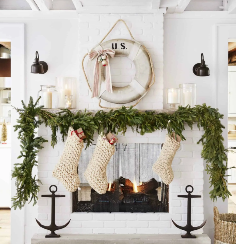 a lush evergreen garland on the mantel, chunky knit white stockings for a pretty coastal Christmas space