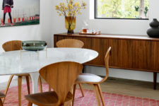 10 The dining space features a round table, some comfy chairs and a glazed wall for views