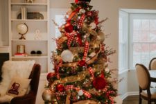 10 a decorated Christmas tree with lights, burlap and plaid ribbons, oversized red, gold and white ornaments abd a hat on top