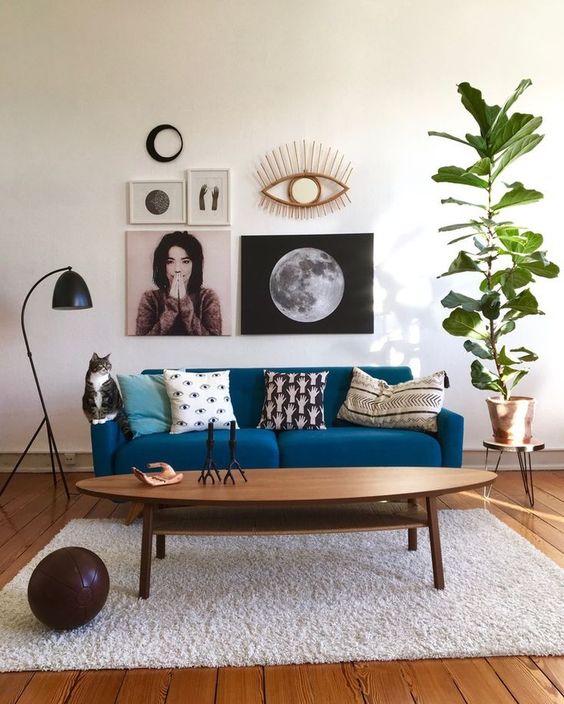 a monochromatic space with a classic blue sofa that adds color and a bright and fashionable touch to the space