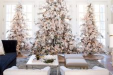 10 a trio of large flocked Christmas trees with lights, neutral and metallic ornaments for a winter fairy-tale in the space