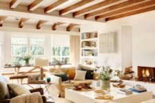 11 a neutral yet warm-toned living room done with whites and wooden beams on the ceiling for a touch of nature