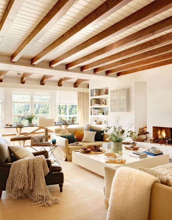 a neutral yet warm-toned living room done with whites and wooden beams on the ceiling for a touch of nature