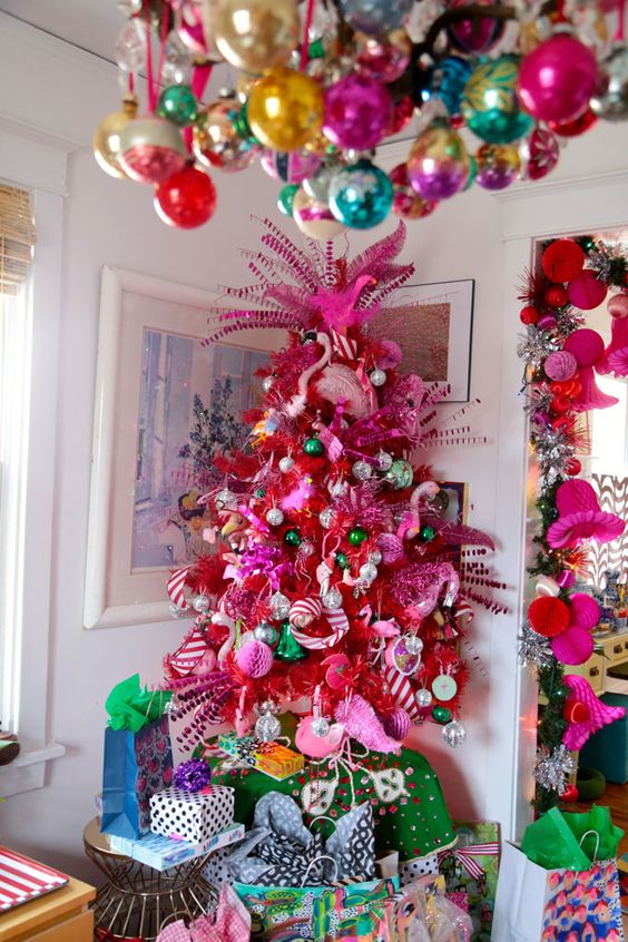 a crazy hot pink Christmas tree with metallic, green and pink ornaments, pink flamingos and striped ribbons