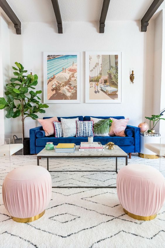 a neutral and pastel living room with a classic blue sofa that adds a bright touch and statement to the space