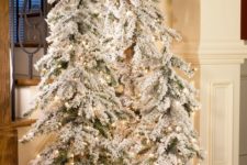 13 create a winter wonderland with a trio of flocked Christmas trees with lights and some white fabric at the base