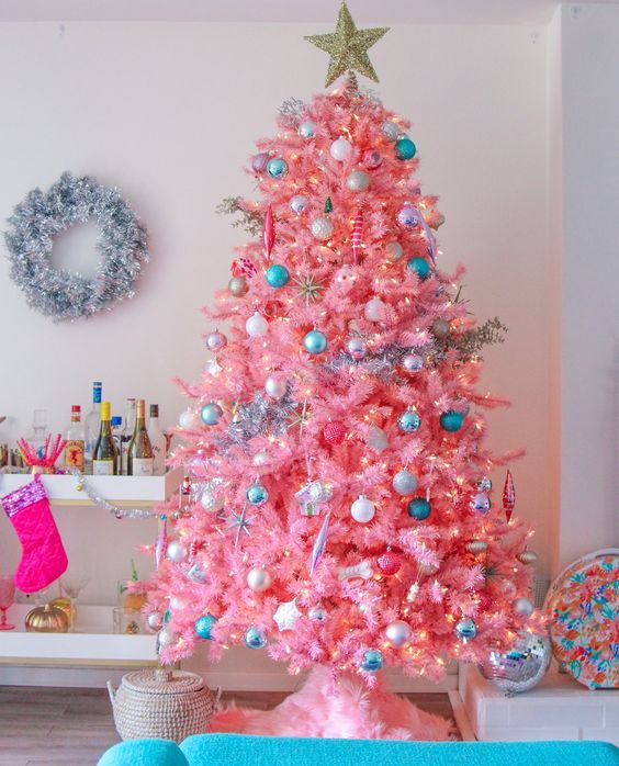 a hot pink Christmas tree with neutral, metallic and blue ornaments and lights