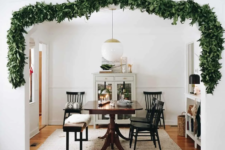 14 a lush greenery garland covering the doorway to bring a slight and chic Christmas feel to the space