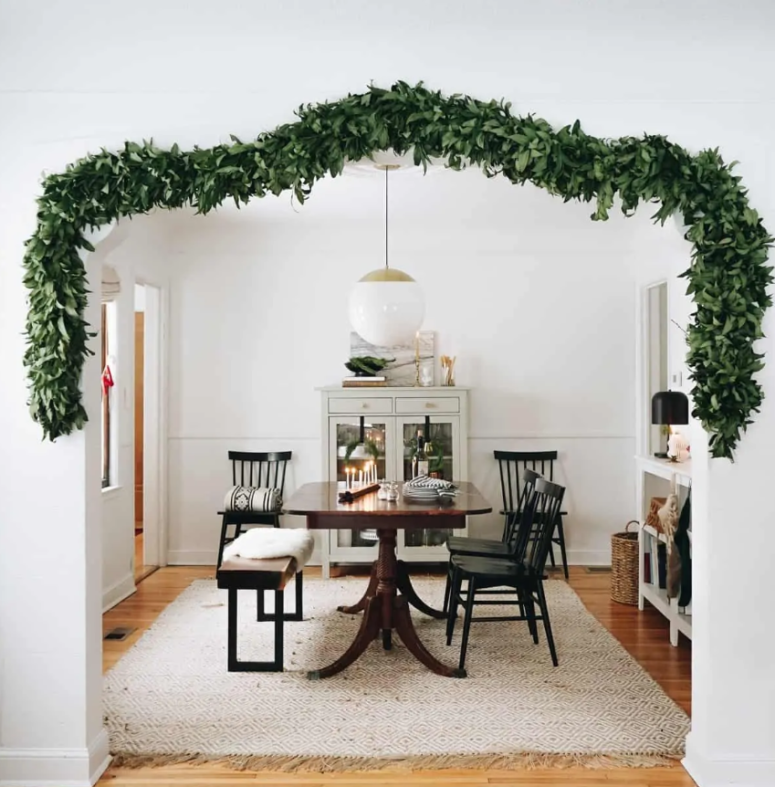 a lush greenery garland covering the doorway to bring a slight and chic Christmas feel to the space