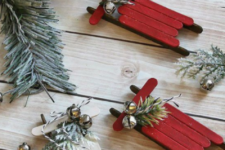 15 red and white Christmas ornaments of popsicle sticks with evergreens and bells will bring a rustic and vintage feel