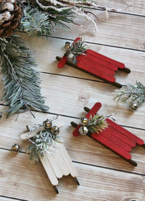red and white Christmas ornaments of popsicle sticks with evergreens and bells will bring a rustic and vintage feel