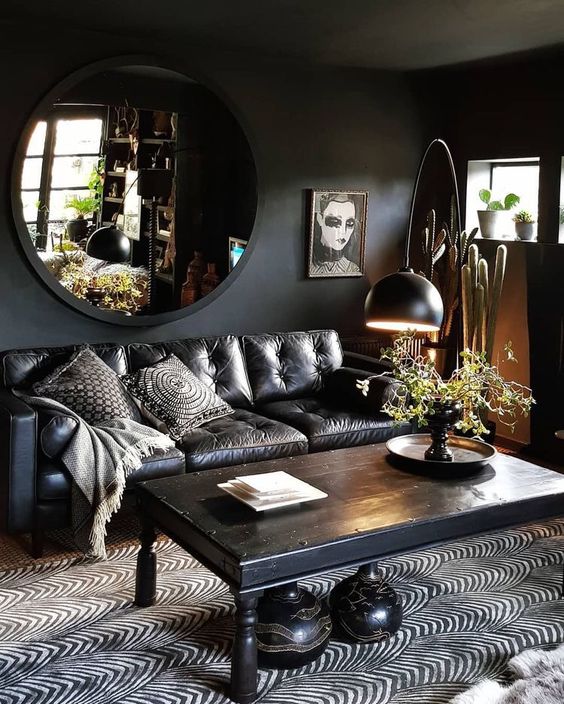 a dark living room with a boho feel, a printed rug and quirky artworks and pillows