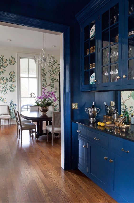a home bar with classic blue cabinets with glass doors looks chic and refined and adds a trendy touch to the space