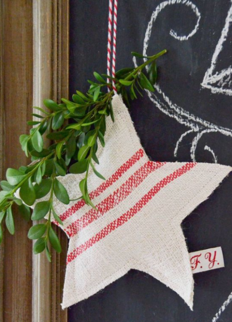 a striped red and white Christmas star ornament with evergreens and red and white twine is a traditional idea