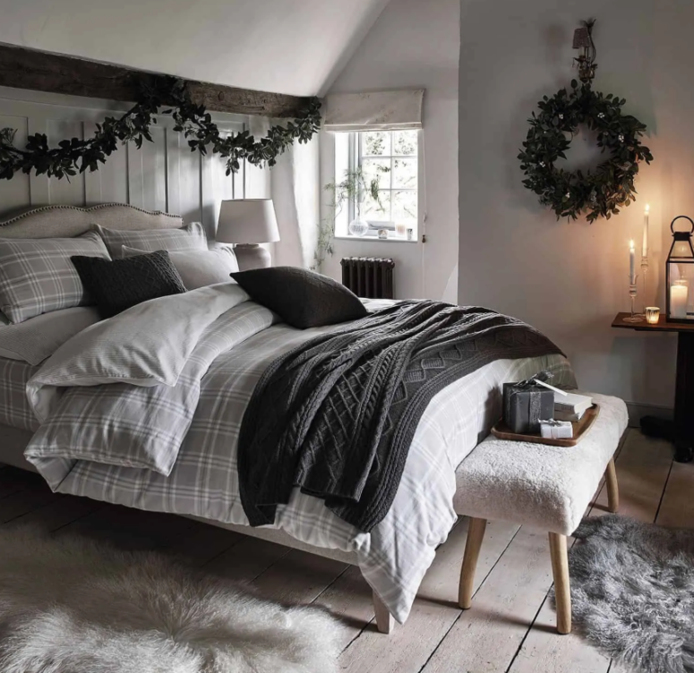 a simple greenery garland over the bed plus a matching wreath on the wall bring a slight Christmas feel to the space