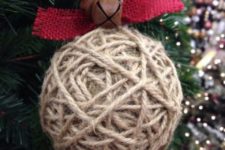 17 a twine wrapped Christmas ornament with red burlap and rust bells is a nice rustic idea with an eye-catchy accent