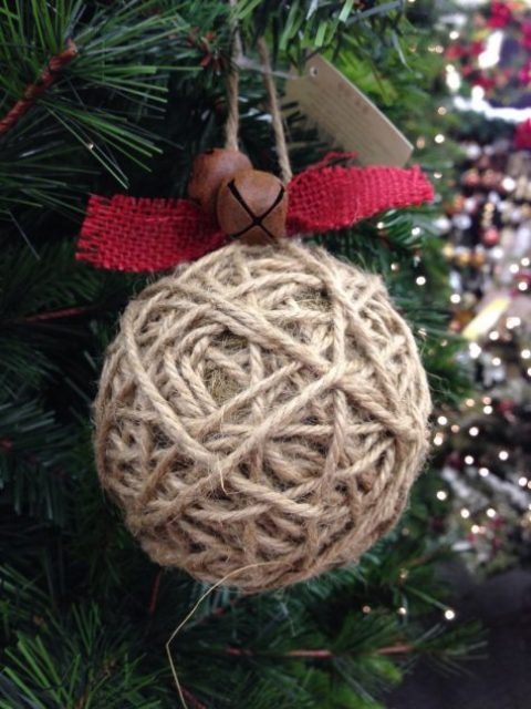 a twine wrapped Christmas ornament with red burlap and rust bells is a nice rustic idea with an eye-catchy accent