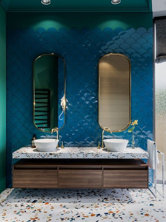 a bold bathroom with a classic blue fish scale tile wall and terrazzo countertops and a floor for a cool look