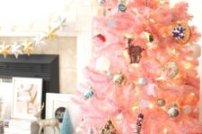 18 a pastel pink Christmas tree with metallic ornaments, lights and retro ones looks as a cute and chic touch of color