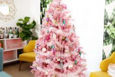 19 a pink Christmas tree decorated with pastel and colorful ornaments and fluffy stuff plus a bright topepr looks retro