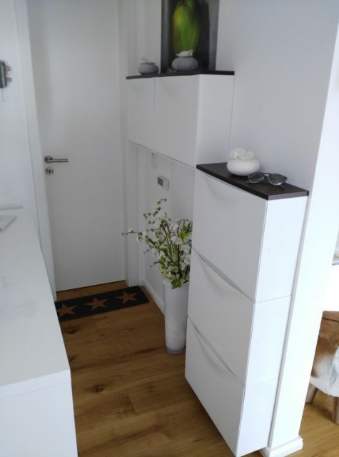 a tiny entryway done with IKEA Trones cabinets and black tabletops that are added for a contrast