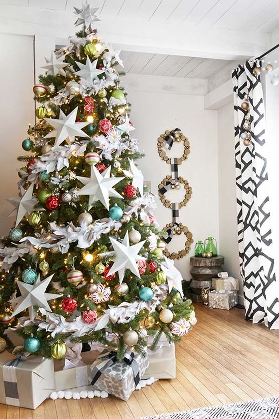 a bright Christmas tree with colorful ornaments, lights and oversized white stars looks catchy