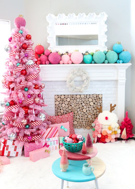 a pink Christmas tree with striped ribbons and oversized metallic and bright ornaments plus matching ones on the mantel
