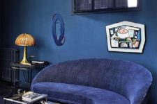 23 a quirky living room with a classic blue wall, a navy sofa, a cool artwork and some retro touches