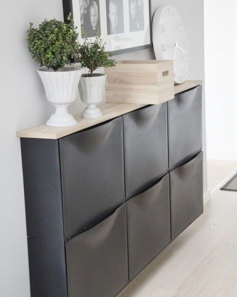 A chic IKEA Trones storage cabinet painted black and given a new top that contrasts it a lot